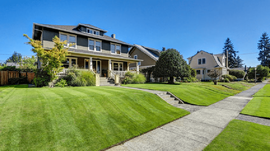 a large, well-maintained lawn with a well-trimmed grassy area in front of a house